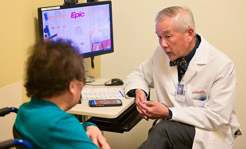 El Dr. CT Lin escucha atentamente a su paciente, Chiang Jones, durante su consulta en las oficinas de medicina interna de UCHealth en Lowry. El Dr. Lin utiliza la herramienta de inteligencia artificial Abridge para tomar notas y así poder concentrarse al 100% en sus pacientes. Foto de Cyrus McCrimmon para UCHealth.